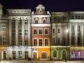Nocny widok na kolorowe kamienice Starego Rynku w Poznaniu, przypominające urokliwe osiedle warszawskie.