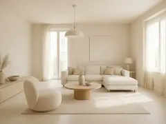 Salon w odcieniach beżu. Miękka sofa, okrągły stolik i puszysty fotel tworzą przytulną przestrzeń. Jak wygląda kolor beżowy? Jak na dłoni!