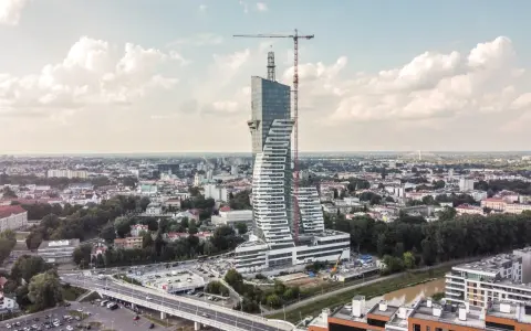 Wielka, kręcona wieża góruje nad miastem. To najwyższy budynek mieszkalny w Polsce, wciąż w budowie, z dźwigiem na szczycie.
