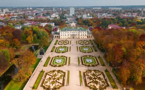 Pałac Branickich w Białymstoku otoczony jesiennym parkiem, z widokiem na rozległą aglomerację miejską.