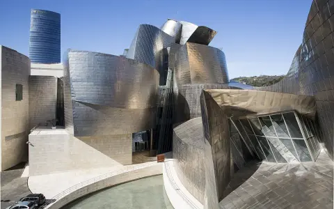 Spektakularny efekt Bilbao: falujące, metaliczne formy Muzeum Guggenheima w Bilbao, odbijające niebo i otoczenie.